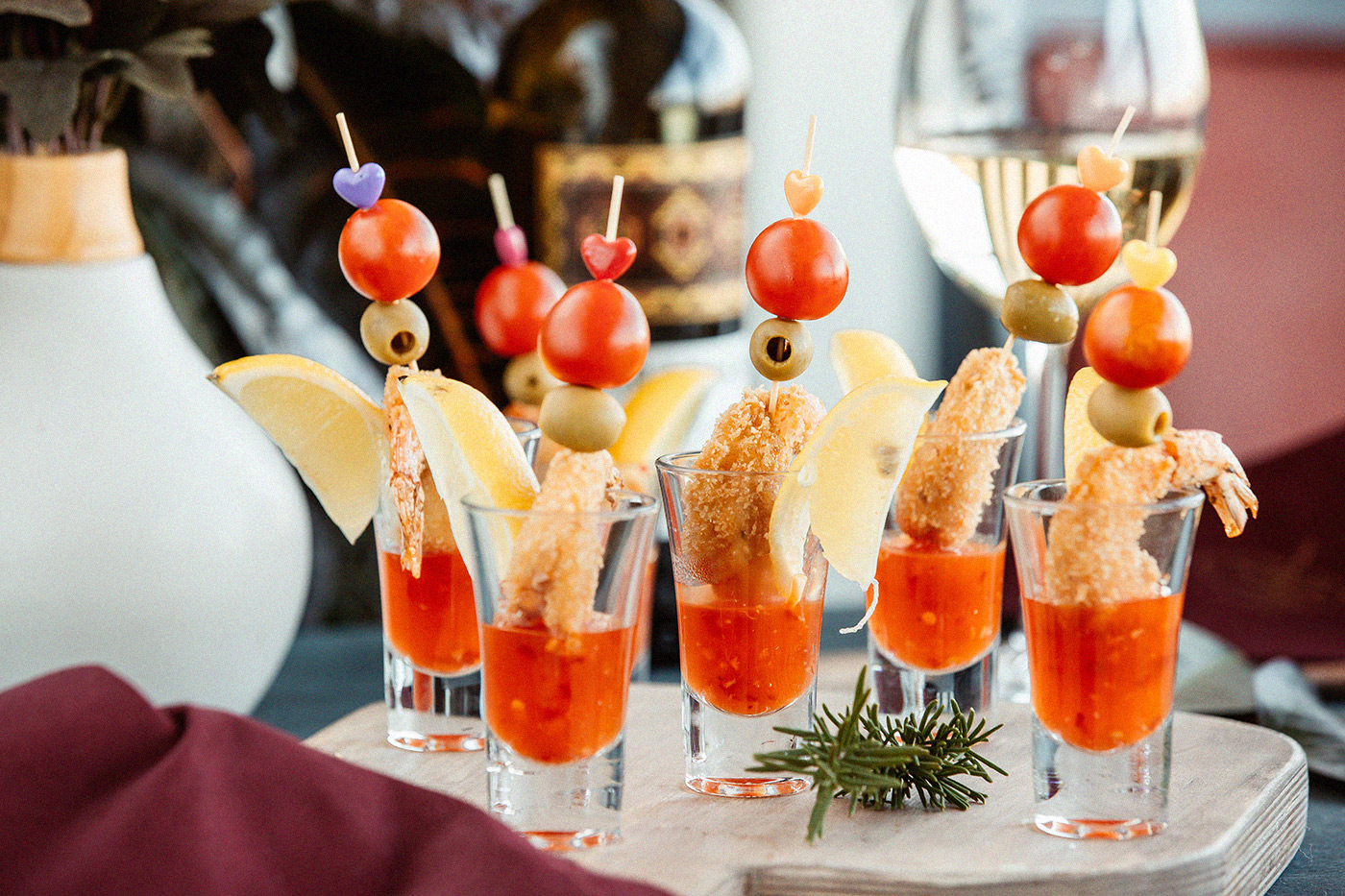 Kreatives Fingerfood: Garnelen in Gläsern mit Dip, garniert mit Oliven, Tomaten und Zitrone